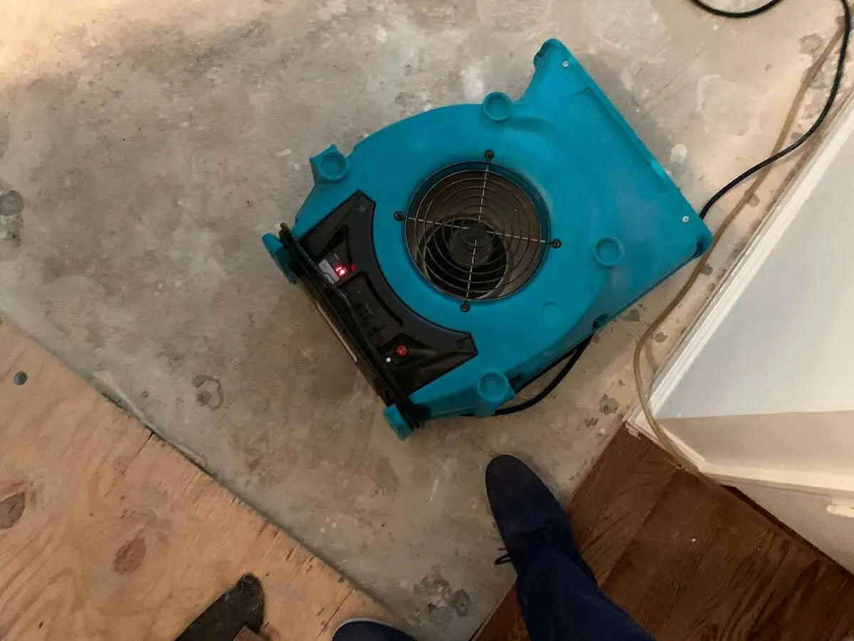 Air mover drying subfloor during Commercial Water Damage Restoration in Canton